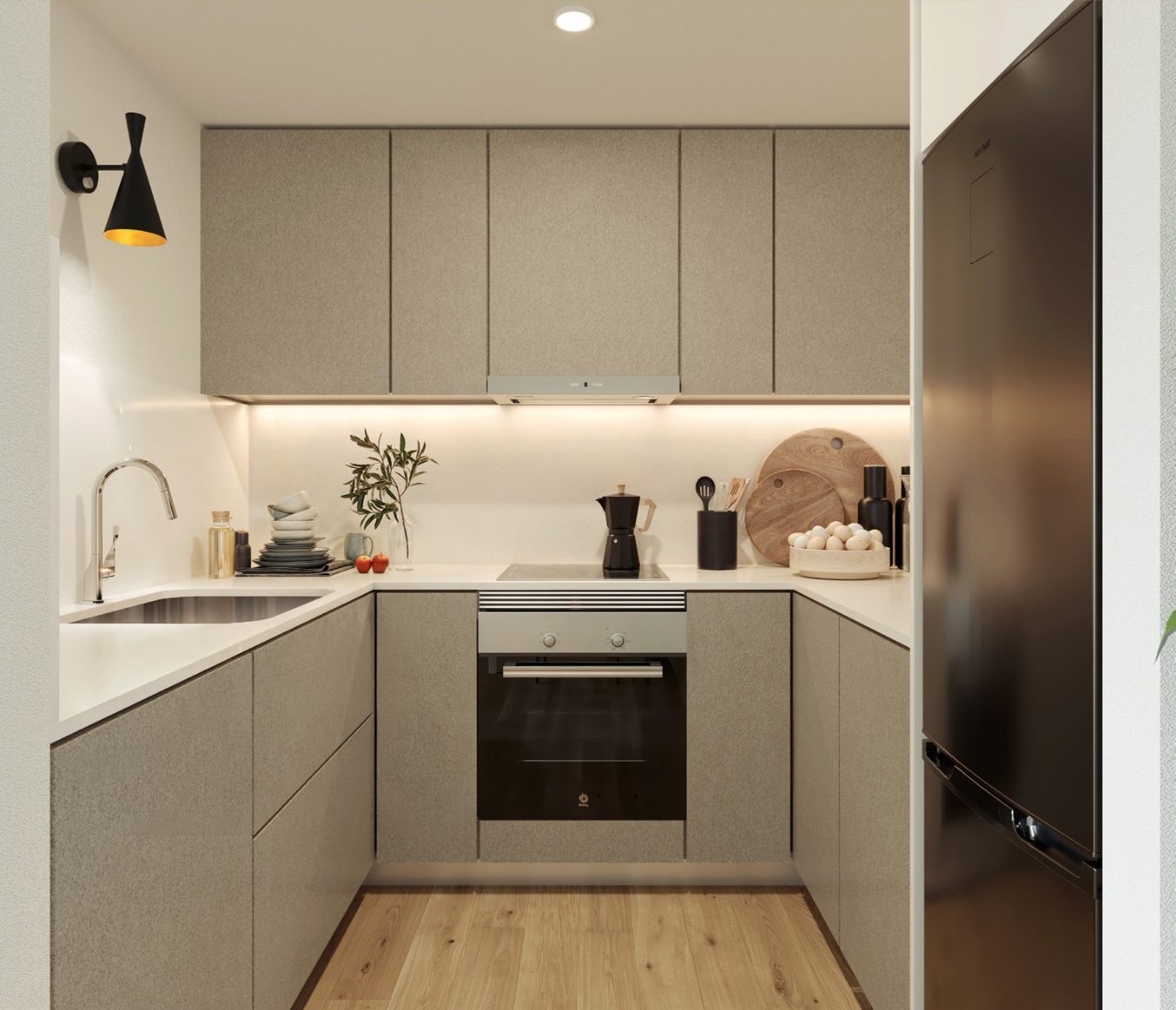 Cocina abierta con muebles claros, encimera continua y horno integrado