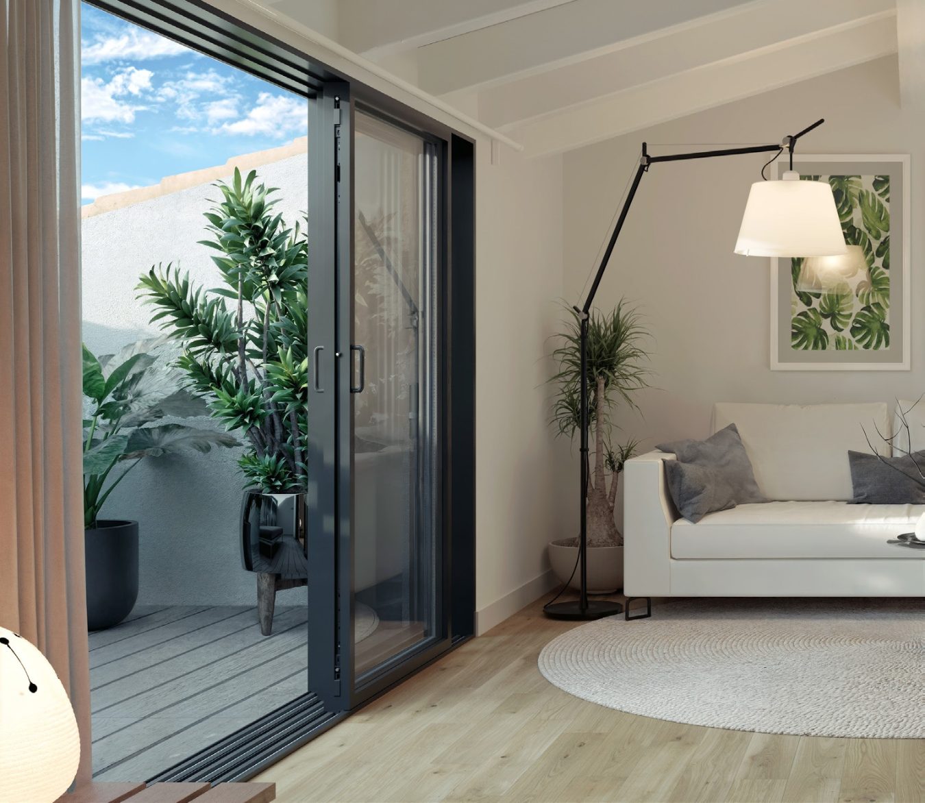 Zona de estar con sofá y puerta corredera de aluminio abierta al exterior